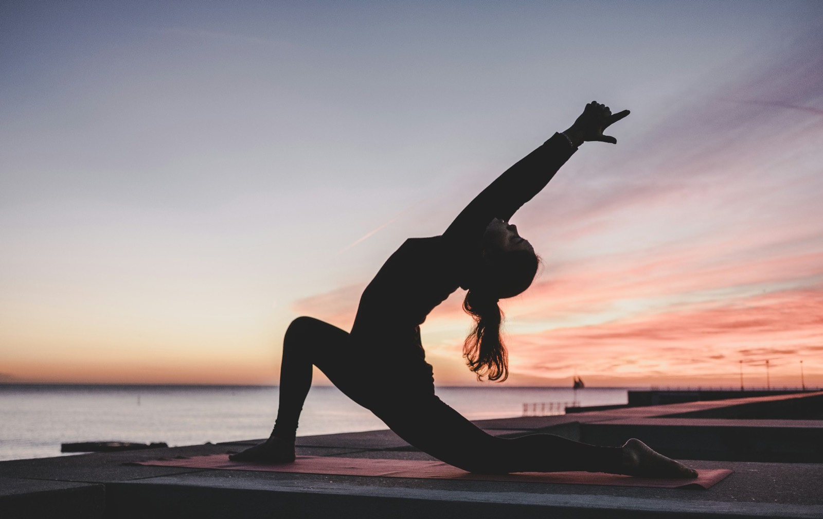 A person doing yoga outdoors, representing self-care and well-being.